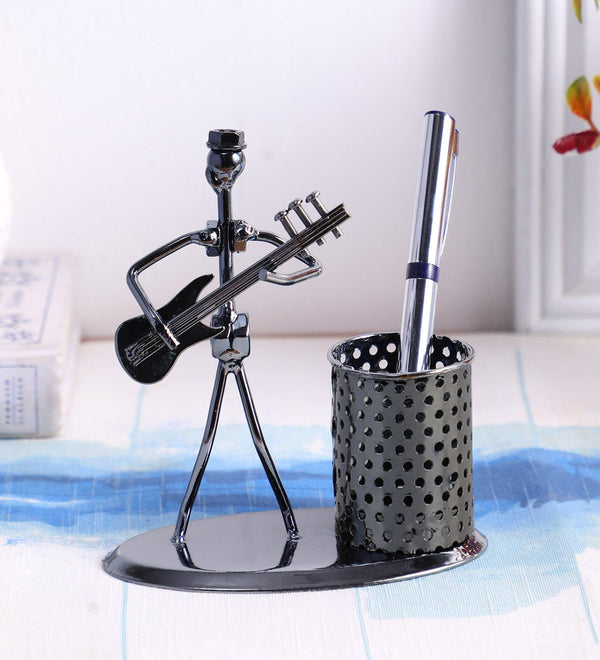 Iron pen stand showpiece of musician playing bass guitar.